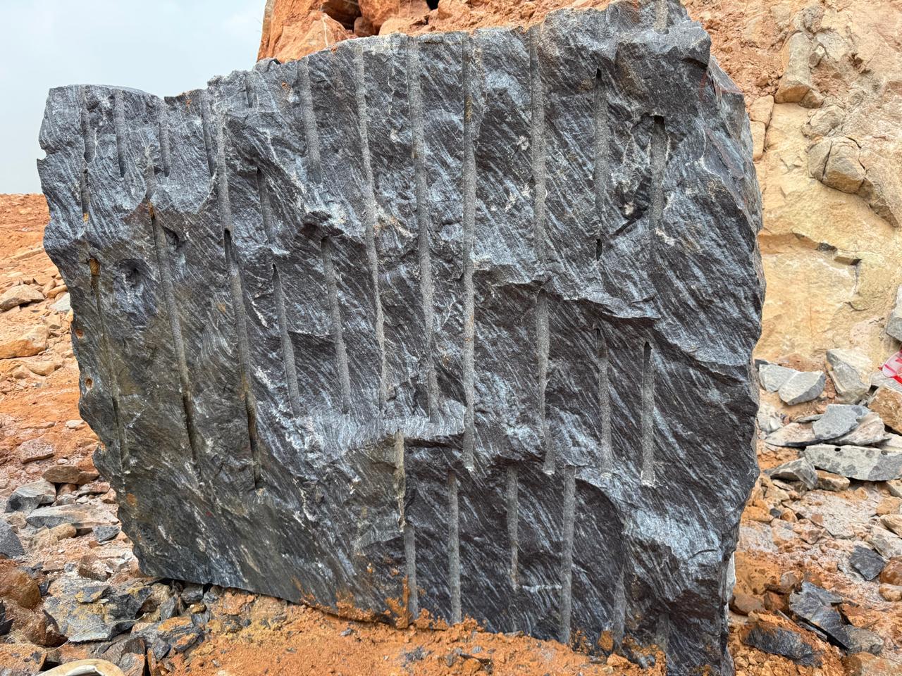 Large Silk Blue granite block at the quarry showing the drill-line splitting marks