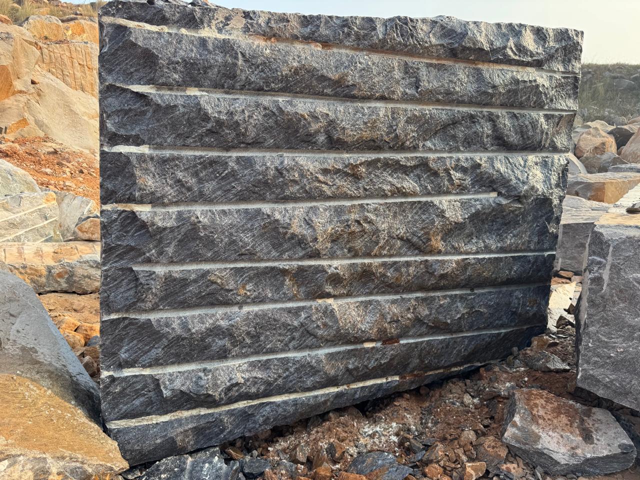 Close-up of a raw Silk Blue granite block face showing deep blue-grey ground and silver veining
